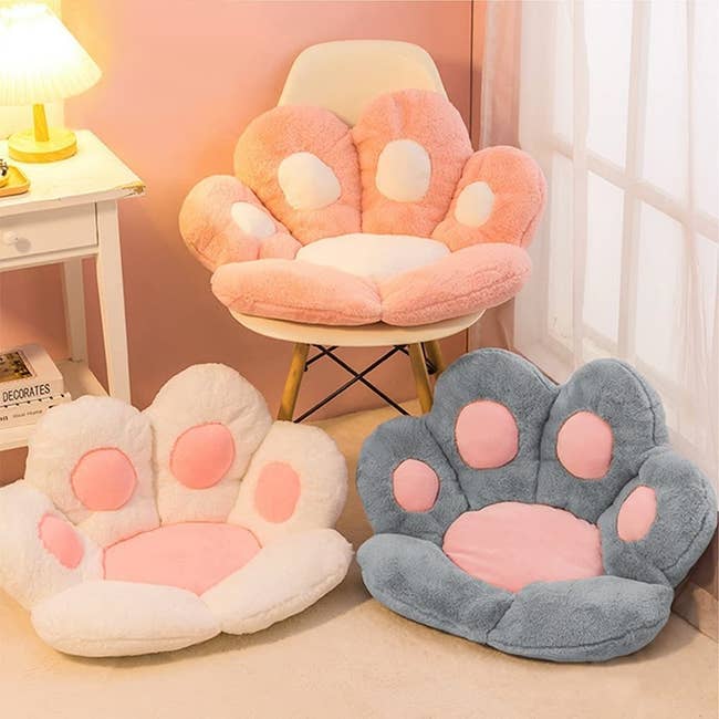 paw shaped pillows in pink, white, and gray 