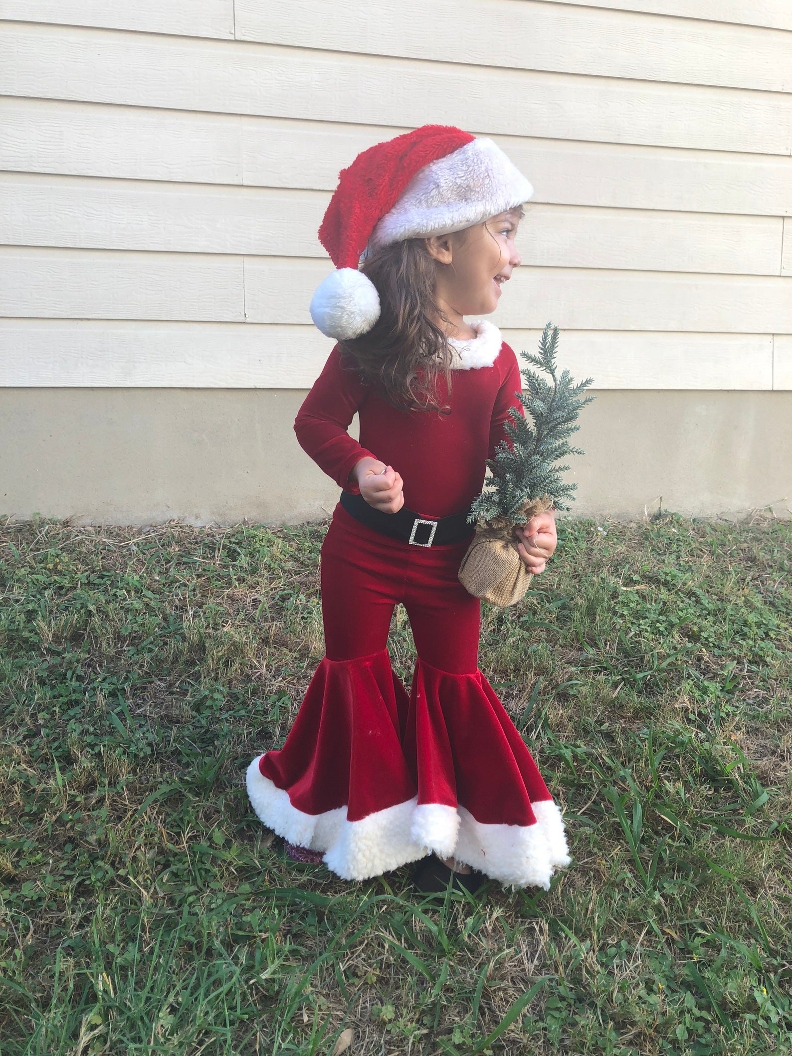 a child in a velvet santa outfit with flare pants