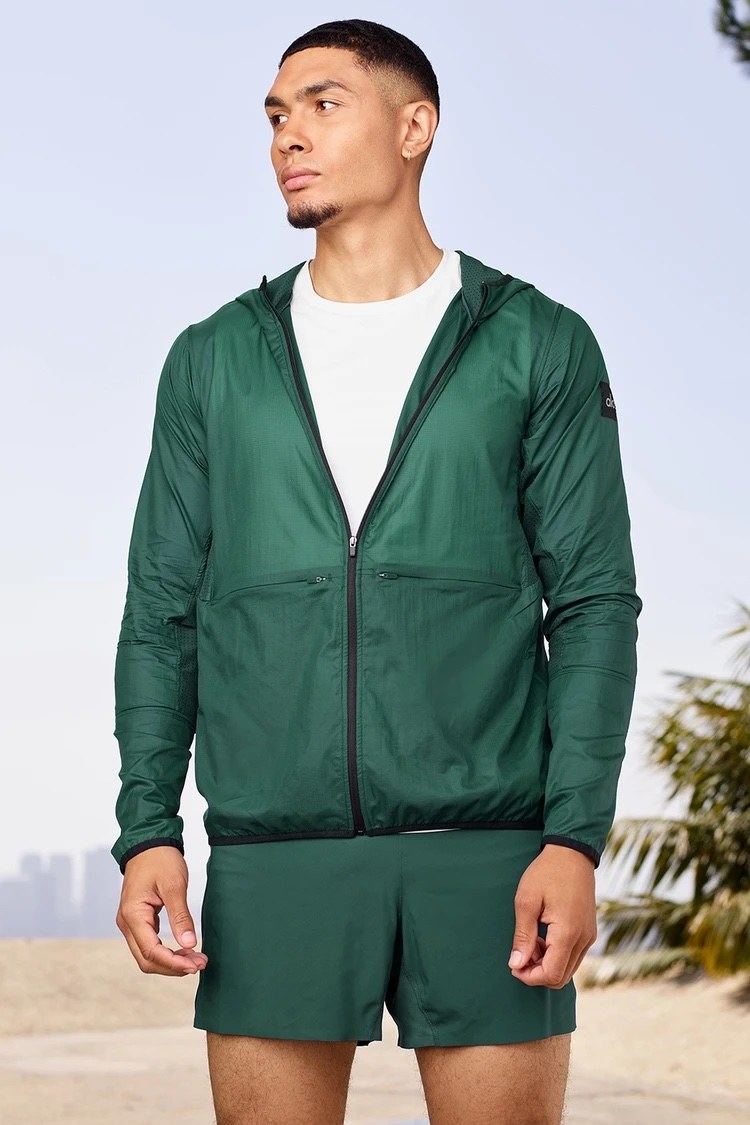 Model waring the lightweight running jacket in green