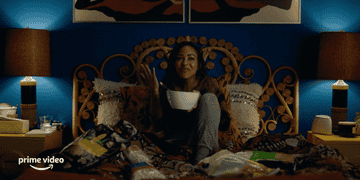 Woman eating cereal in bed.