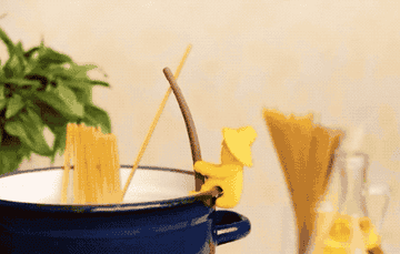gif of spaghetti pot with fisherman figure on the side of the post holding one piece of spaghetti that is then eaten