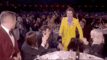 Harry Styles excitedly throwing his fist in the air