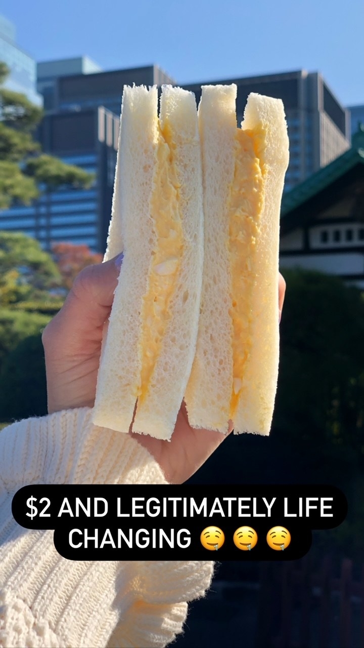 Me holding an egg salad sandwich in Tokyo