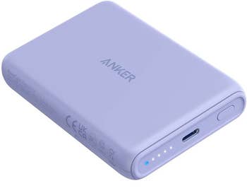 a side view of the purple charger, showing the USB-C port, power button, and battery life lights.