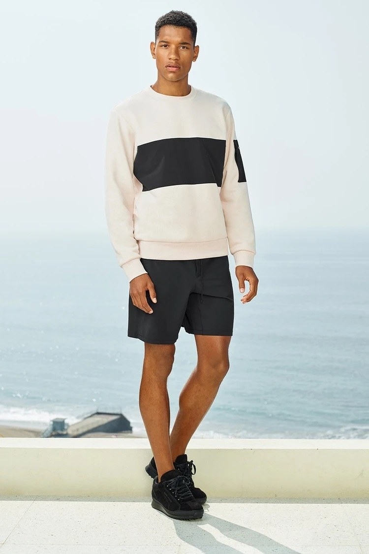 Model wearing the white sweatshirt with large black stripe on the chest