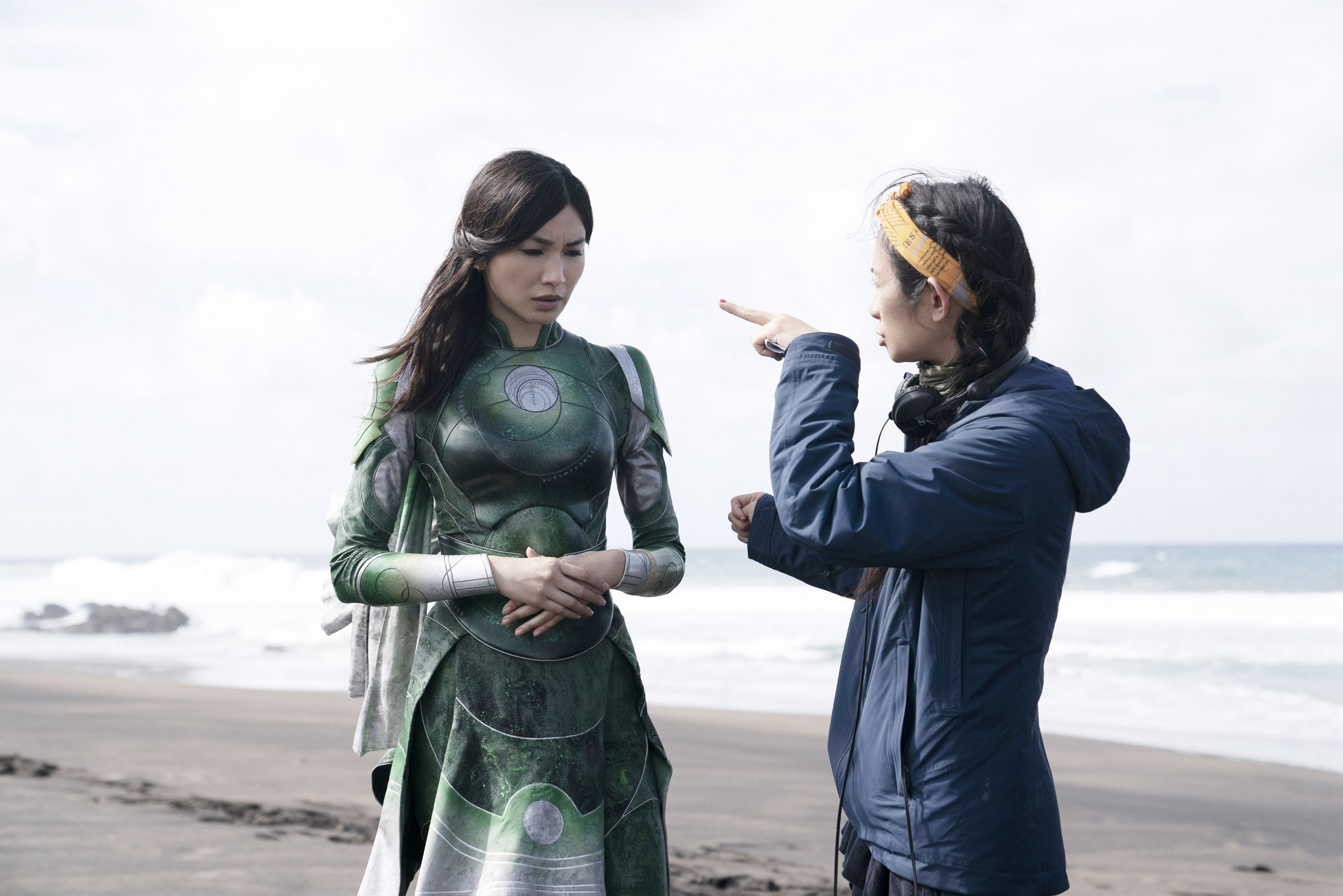 Chloé giving direction to Gemma Chan on a beach set