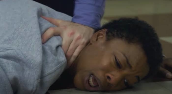 Poussey being held down on the floor