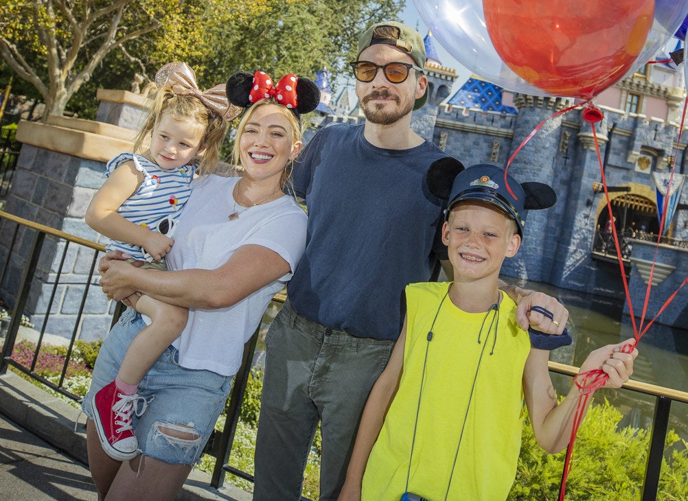 Hilary poses at Disneyland with her older daughter and son