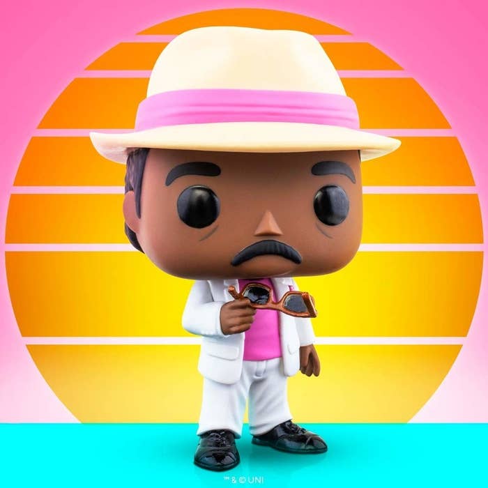 A Funko Pop of Stanley from The Office in front of a sunset background