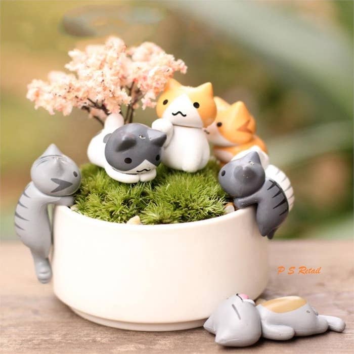 Cat figurines around a flower pot