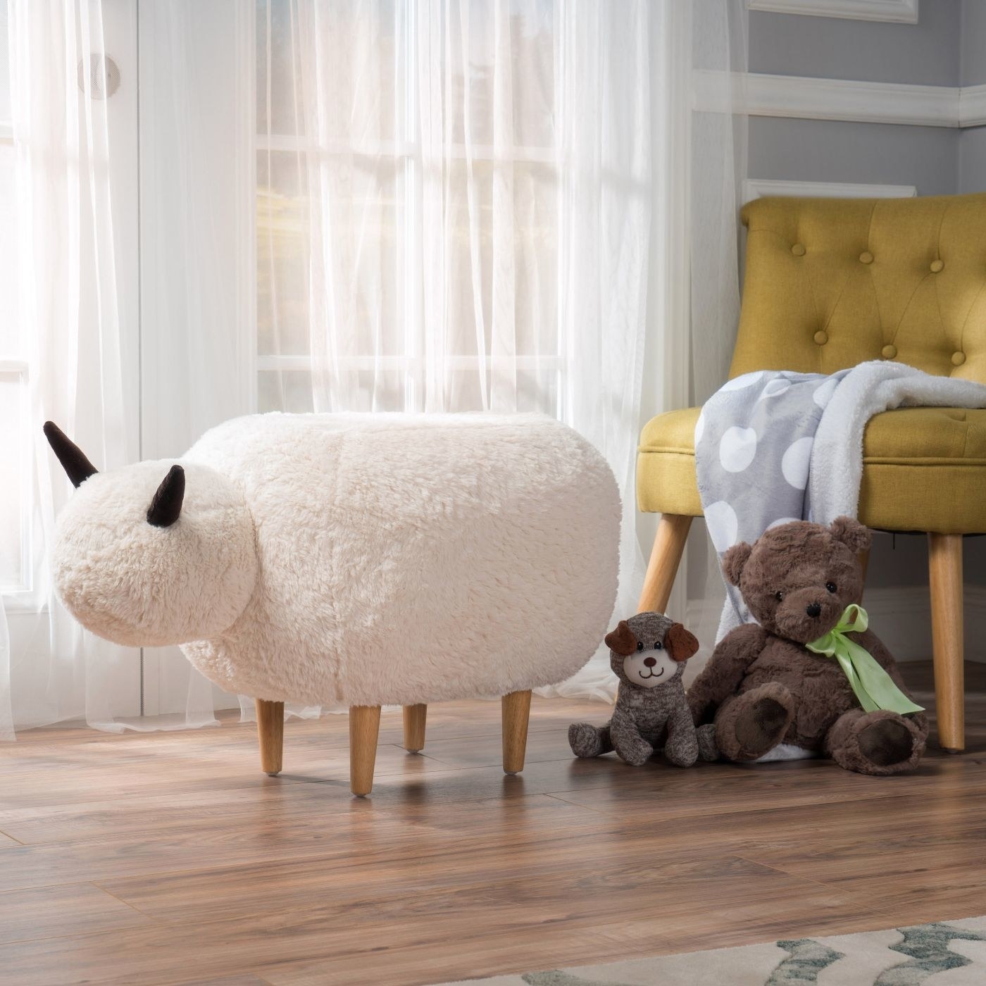 Fluffy white sheep ottoman in front of a mustard armchair with a blanket draped on top