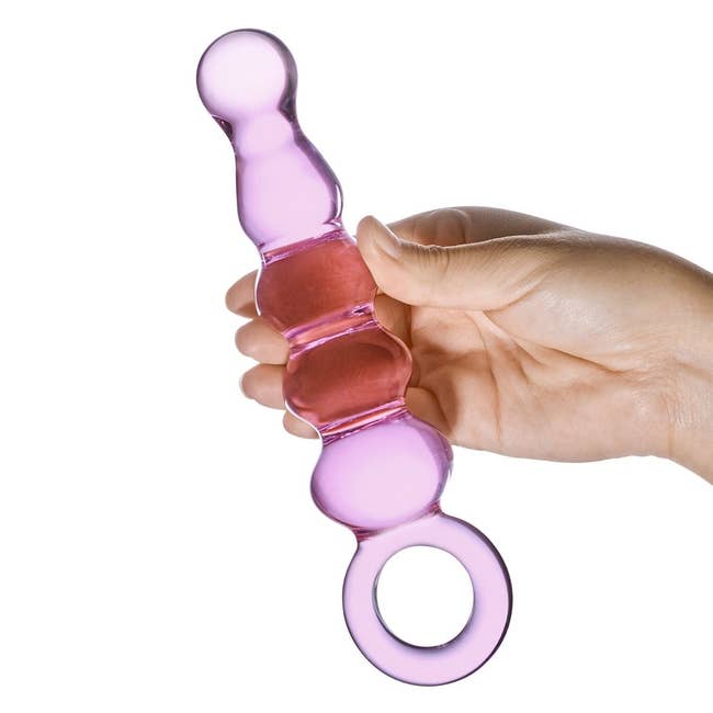 Model holding pink beaded glass plug