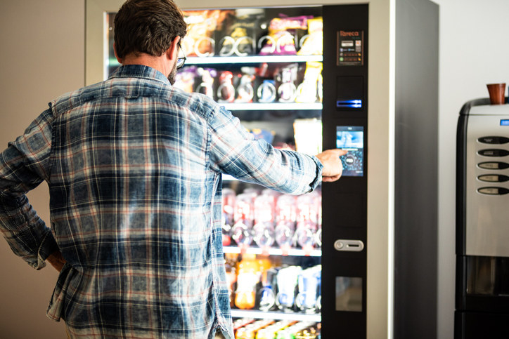 a man getting a snack from a vending machine