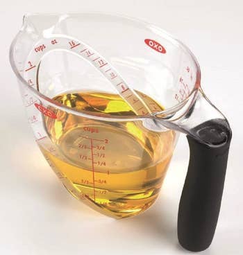 The measuring cup holding one cup of liquid, determined by reading side and overhead measurements