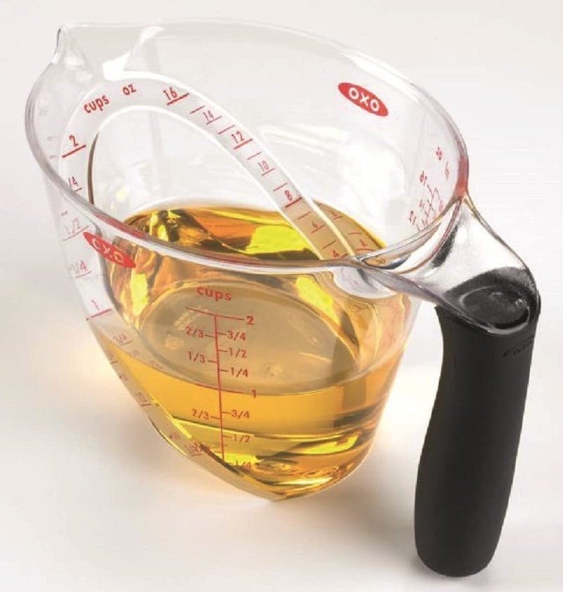 The measuring cup holding one cup of liquid, determined by reading side and overhead measurements