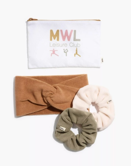 the gift set with one green and one white scrunchie as well as a brown knotted headband and a zippered pouch with the words &quot;MWL leisure club&quot; on it and three figurines doing yoga moves