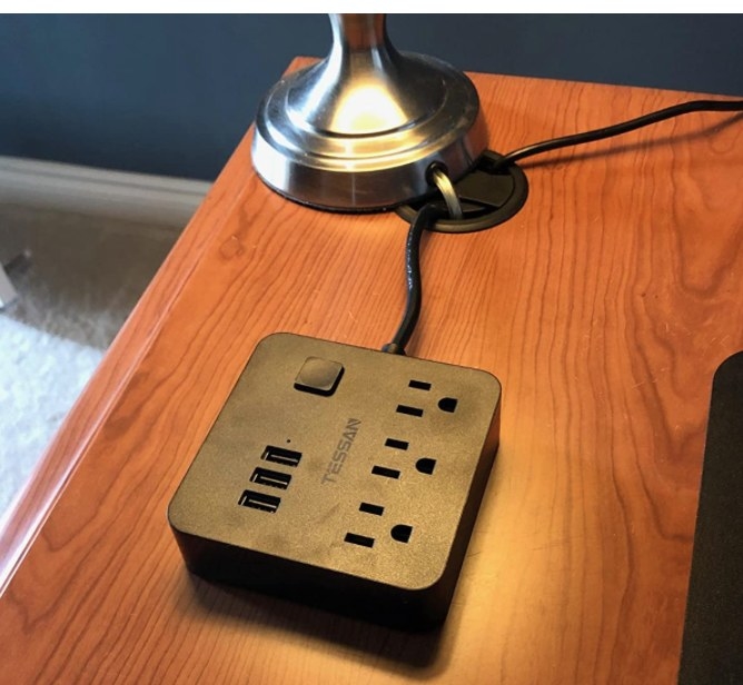A black power strip on a reviewer&#x27;s brown table