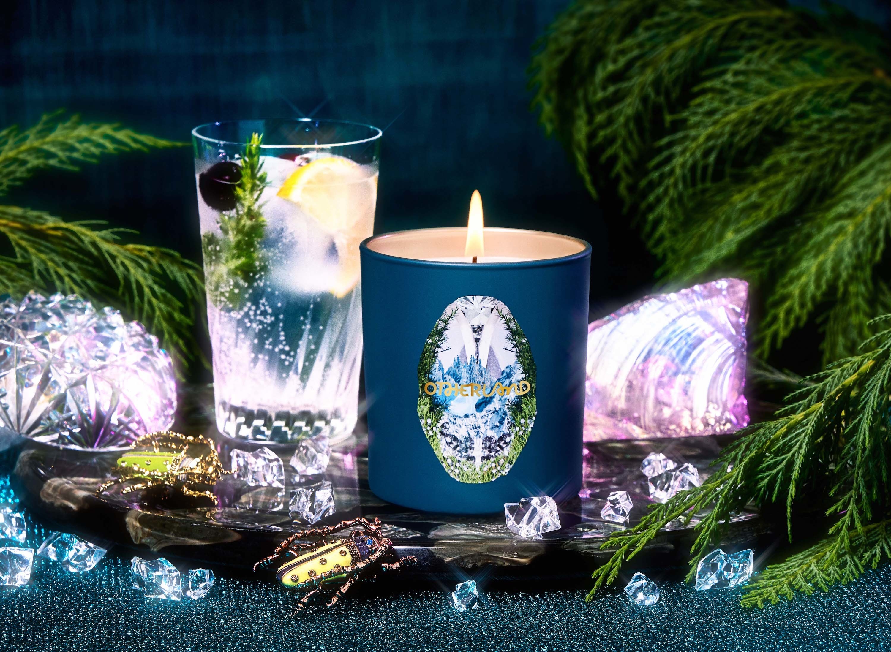a dark blue candle with a forest on it