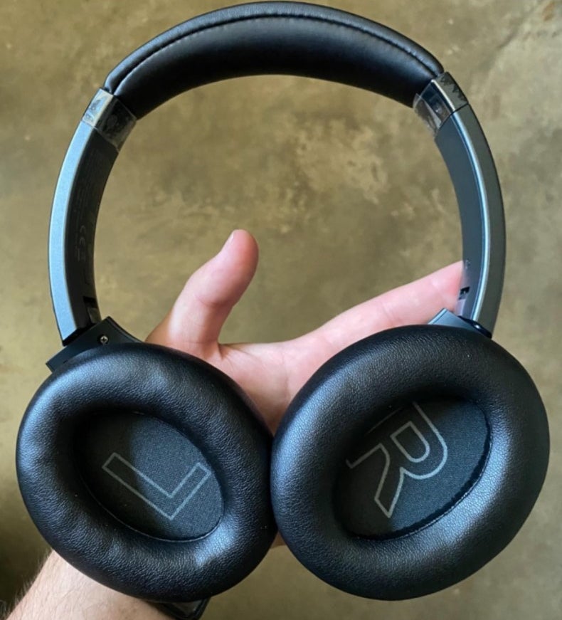 A pair of large headphone in a reviewer&#x27;s hand