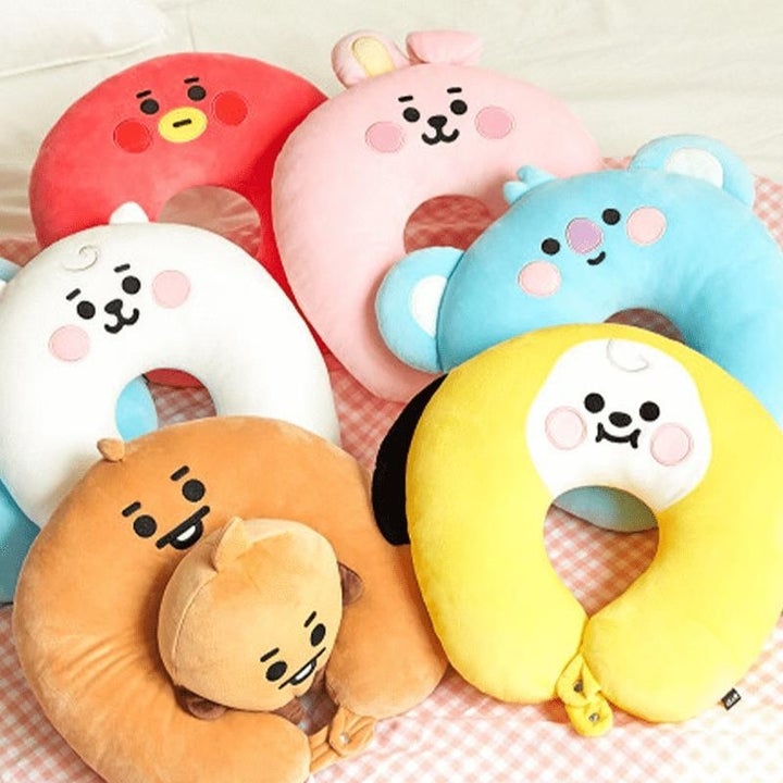 a flatlay of all the bt21 characters as neck pillows