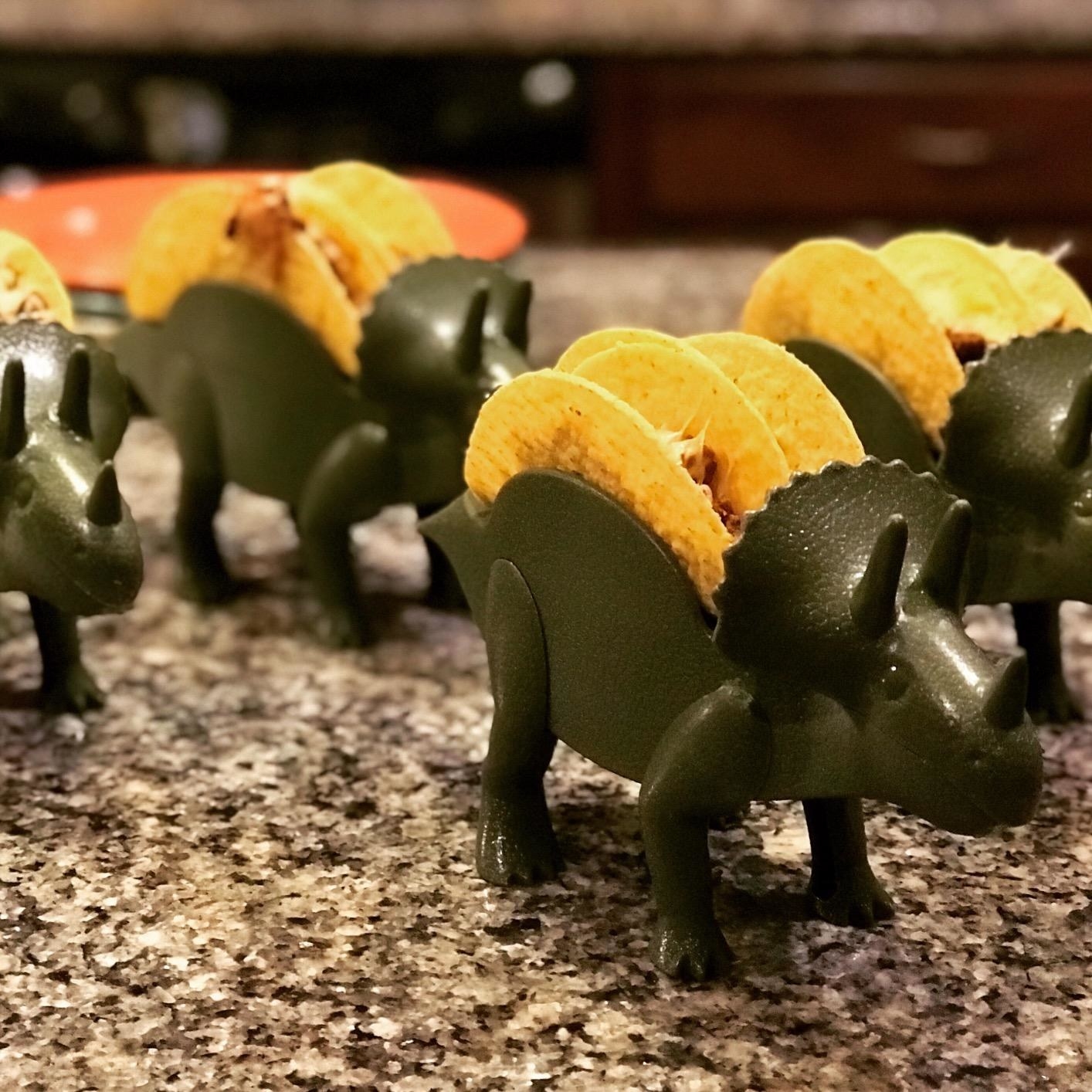reviewer&#x27;s dino taco holder with a taco in it