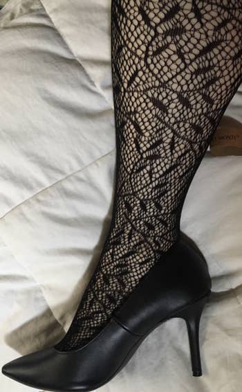 reviewer wearing patterned stockings with black heels