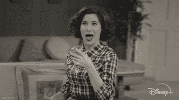 a black and white gif of Agatha in &quot;Wanda Vision&quot; smiling and giving a thumbs up