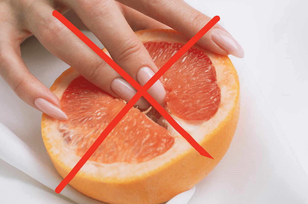 A woman&#x27;s fingers on a grapefruit
