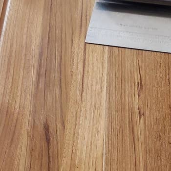 Reviewer photo of the bench scraper on a wooden cutting board