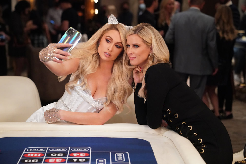 Paris and Nicky Hilton pose at a casino table for a selfie