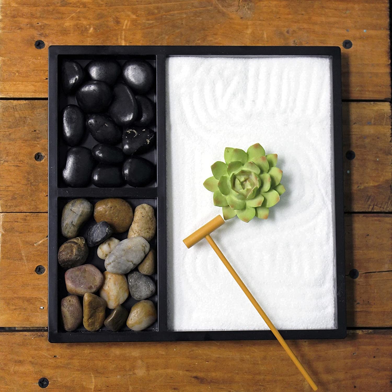 a garden with stones, a rake, and sand