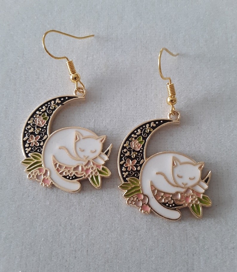 white cats sitting on black floral moon earrings