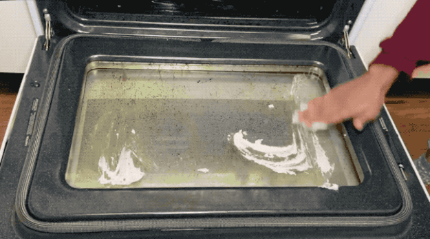 GIF of someone applying the scrub to a dirty oven door