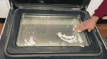 GIF of someone applying the scrub to a dirty oven door