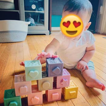 reviewer's baby playing with the stacked pastel blocks