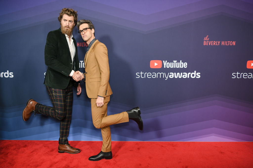 Rhett and Link shaking hands and popping their legs up on the red carpet of the Streamy Awards