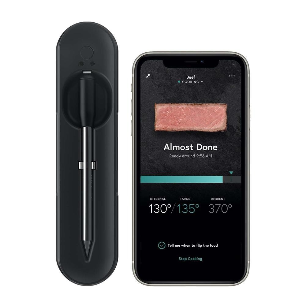 The Yummly® Smart Thermometer and a phone with the Yummly app.