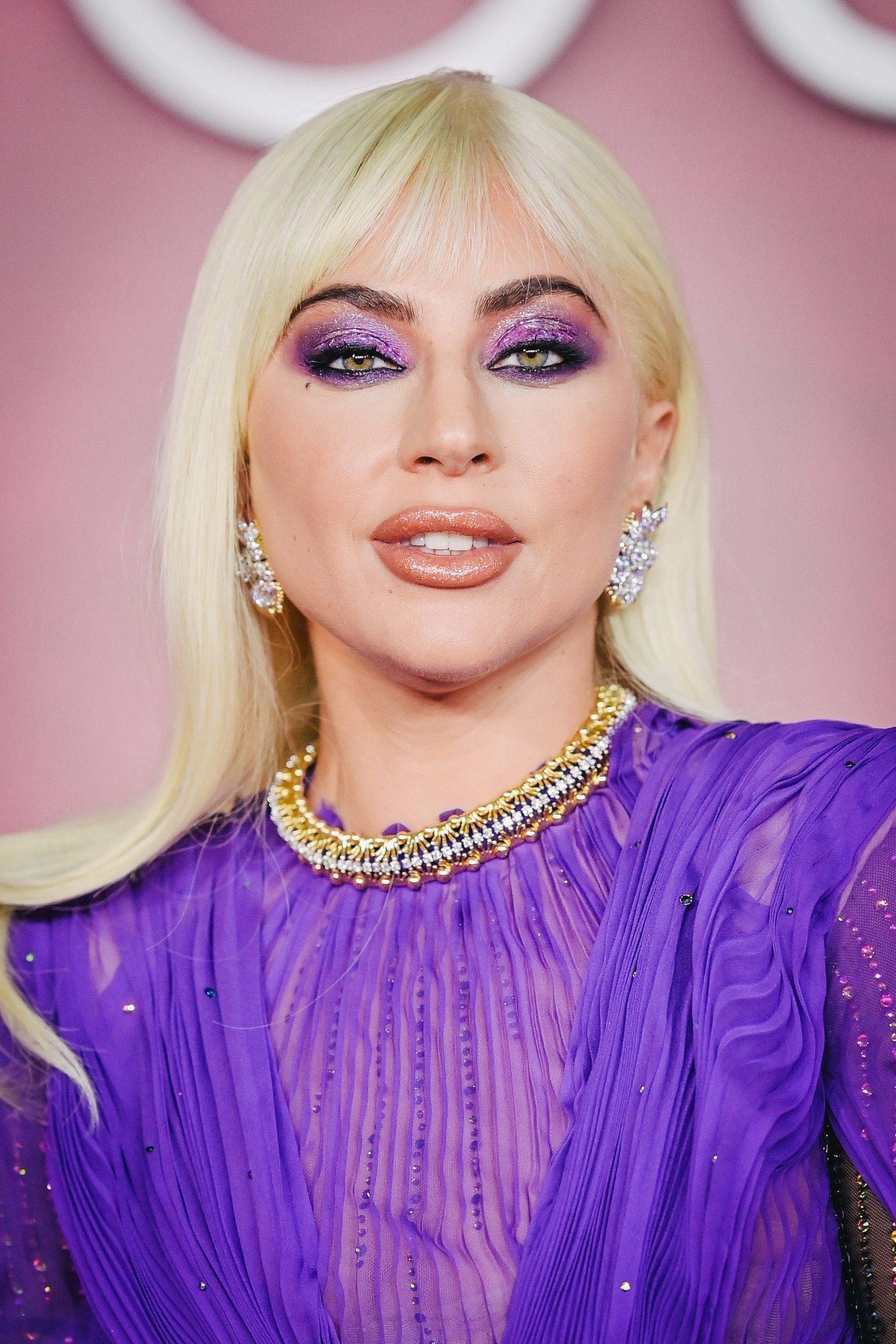 A close-up of Gaga&#x27;s makeup, in which she has purple shimmer eyeshadow and a peach lip