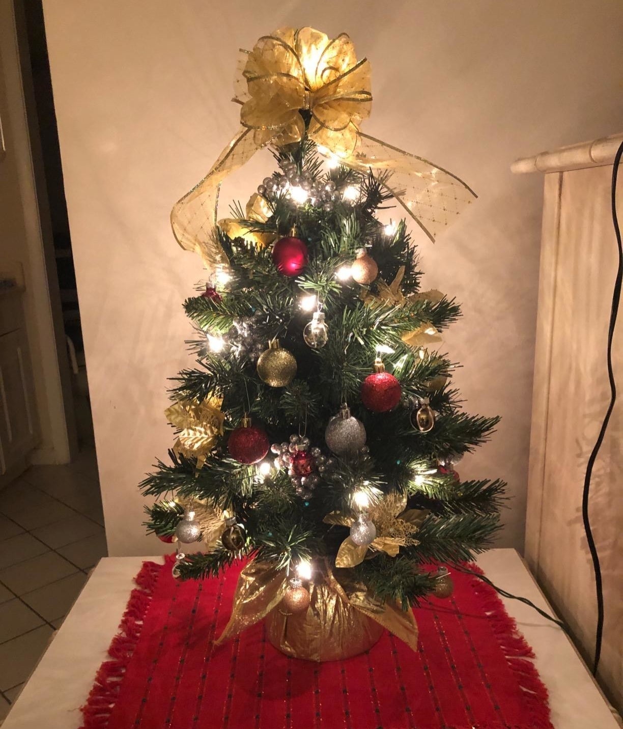 A reviewer&#x27;s tabletop tree lit up with ornaments placed on it