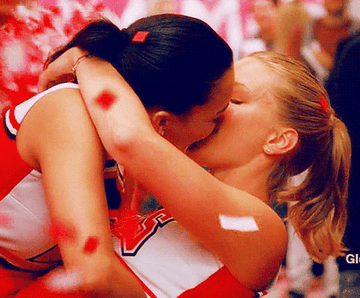 Naya Rivera as Santana and Heather Morris as Brittany kiss while confetti falls in &quot;Glee&quot;