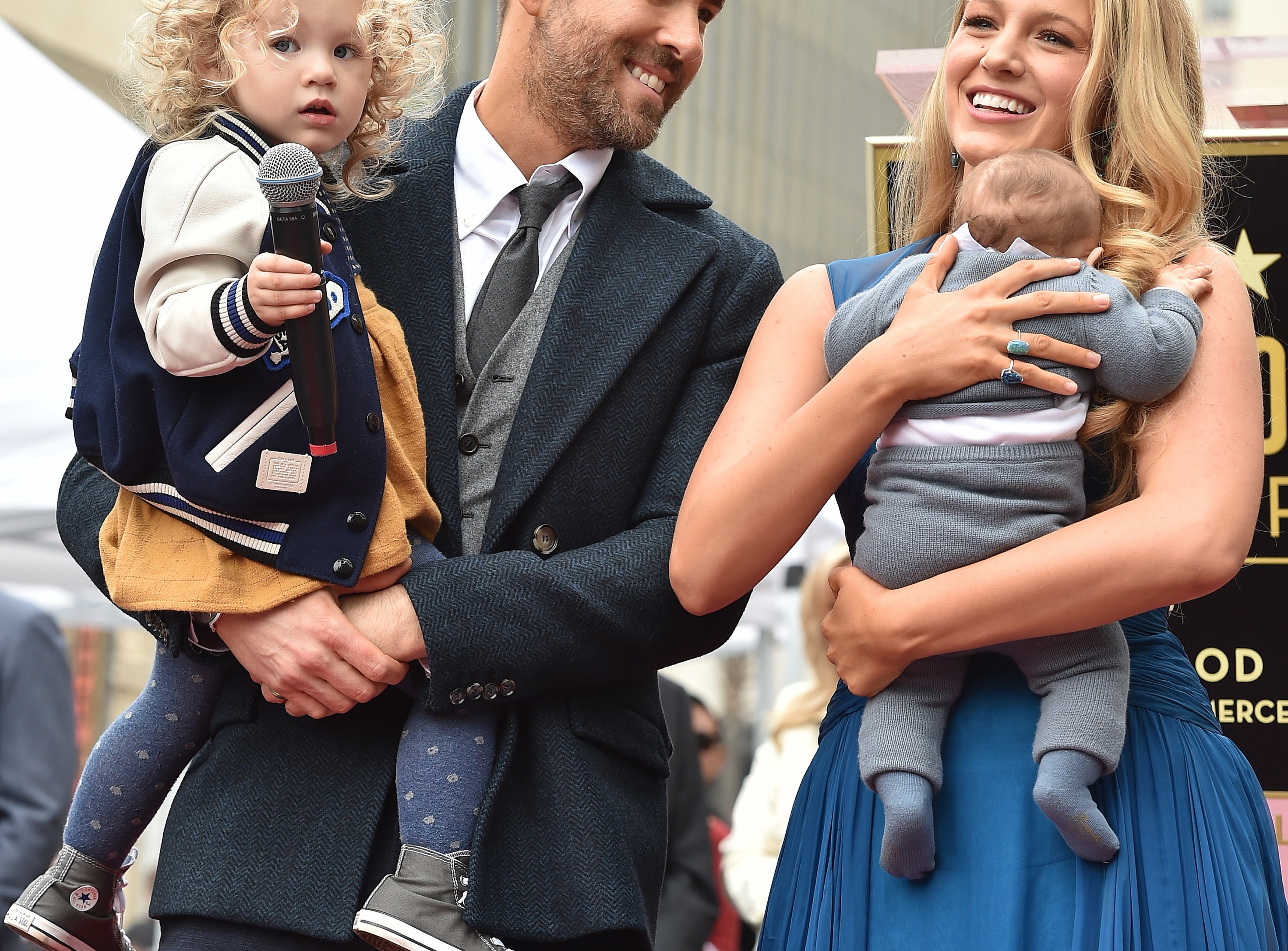 Blake and Ryan hold two of their children at an event