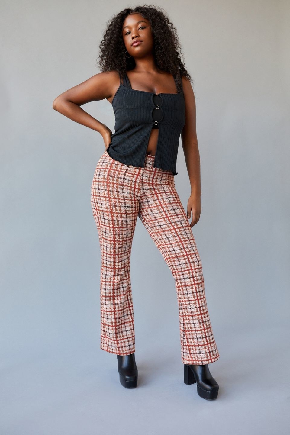 A model in the white, rust, and black plaid pants