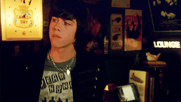 teen boy with shaggy hair looks around a room