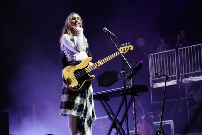 Este stands on stage with her bass