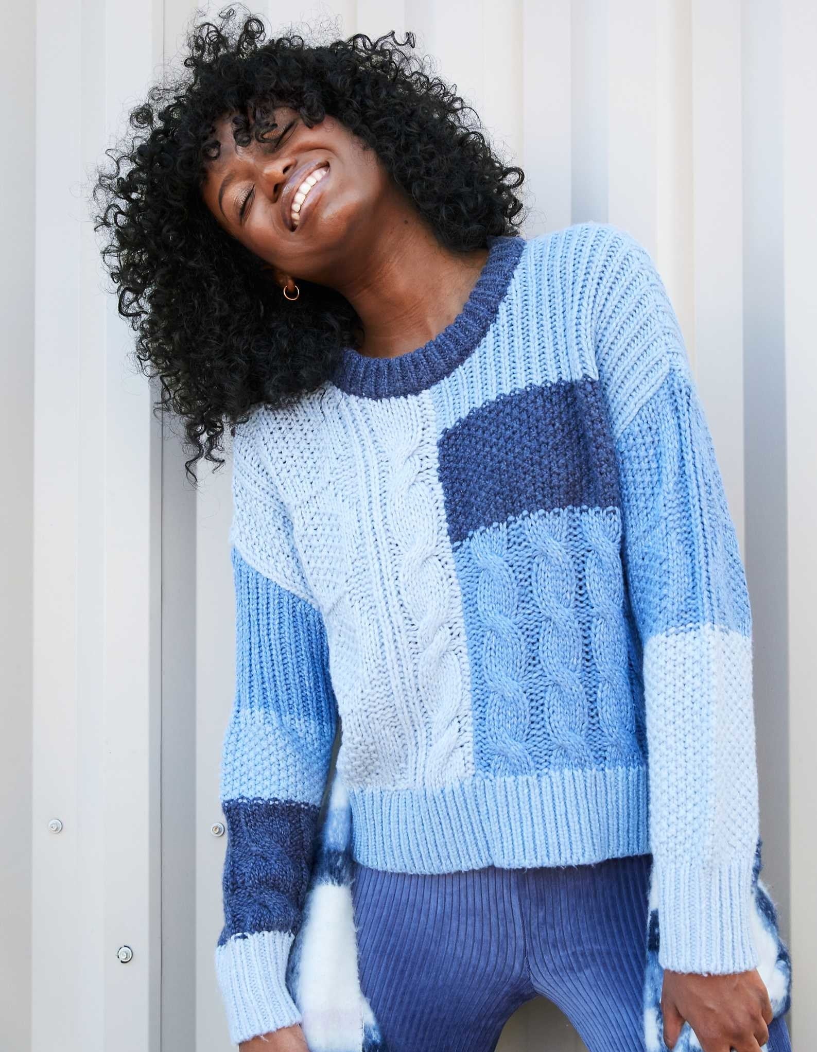 model in monochromatic blue sweater with different panels of ribbing and cabling