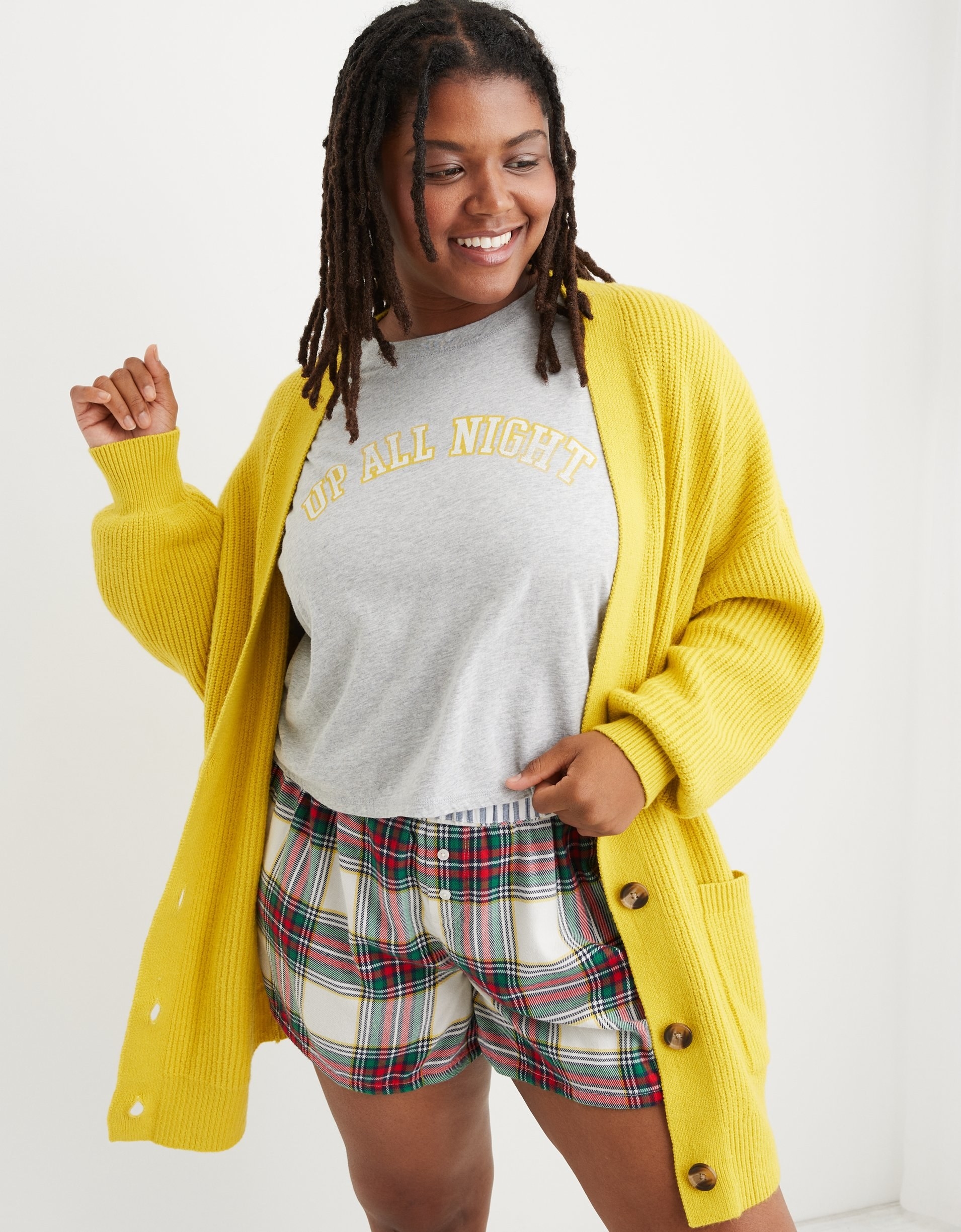 model in a bright yellow long knit cardigan with tortoise shell buttons