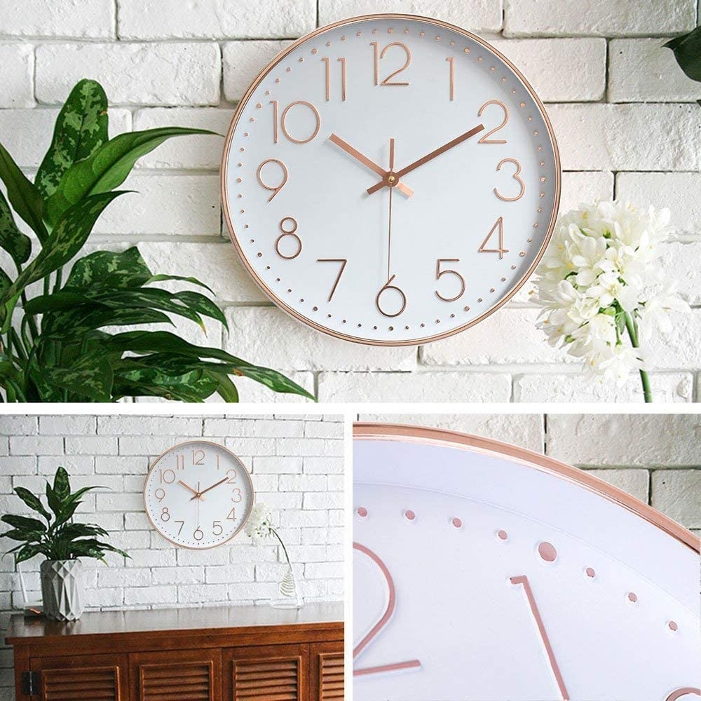 A rose gold analog clock hanging on wall