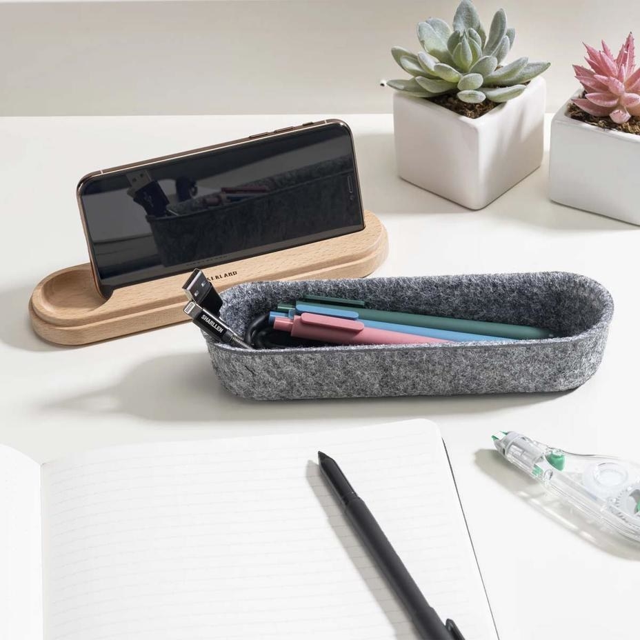the gray felt pencil case open and wood lid removed and holding a phone