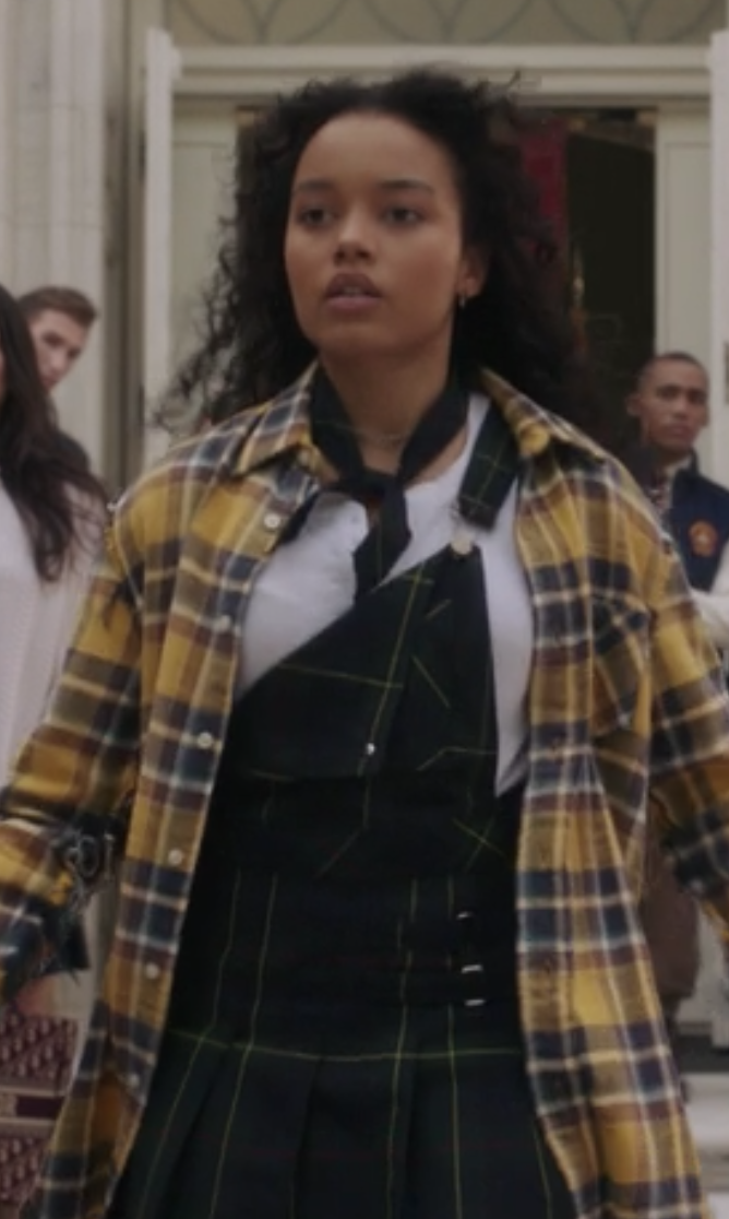 Zoya Lott wears a one strap plaid jumper under an oversized plaid shirt