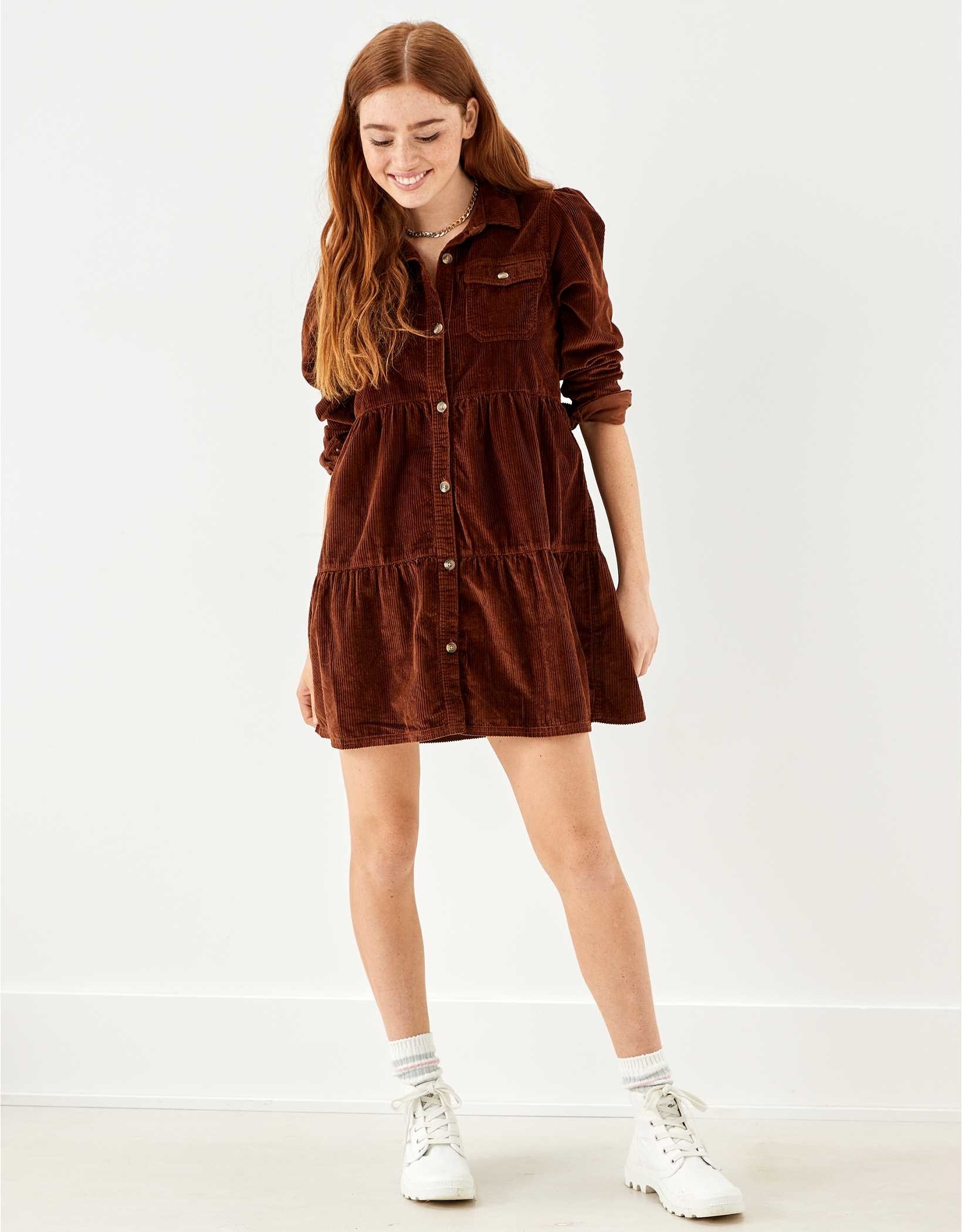 Model wearing the rust dress with crew socks and sneakers